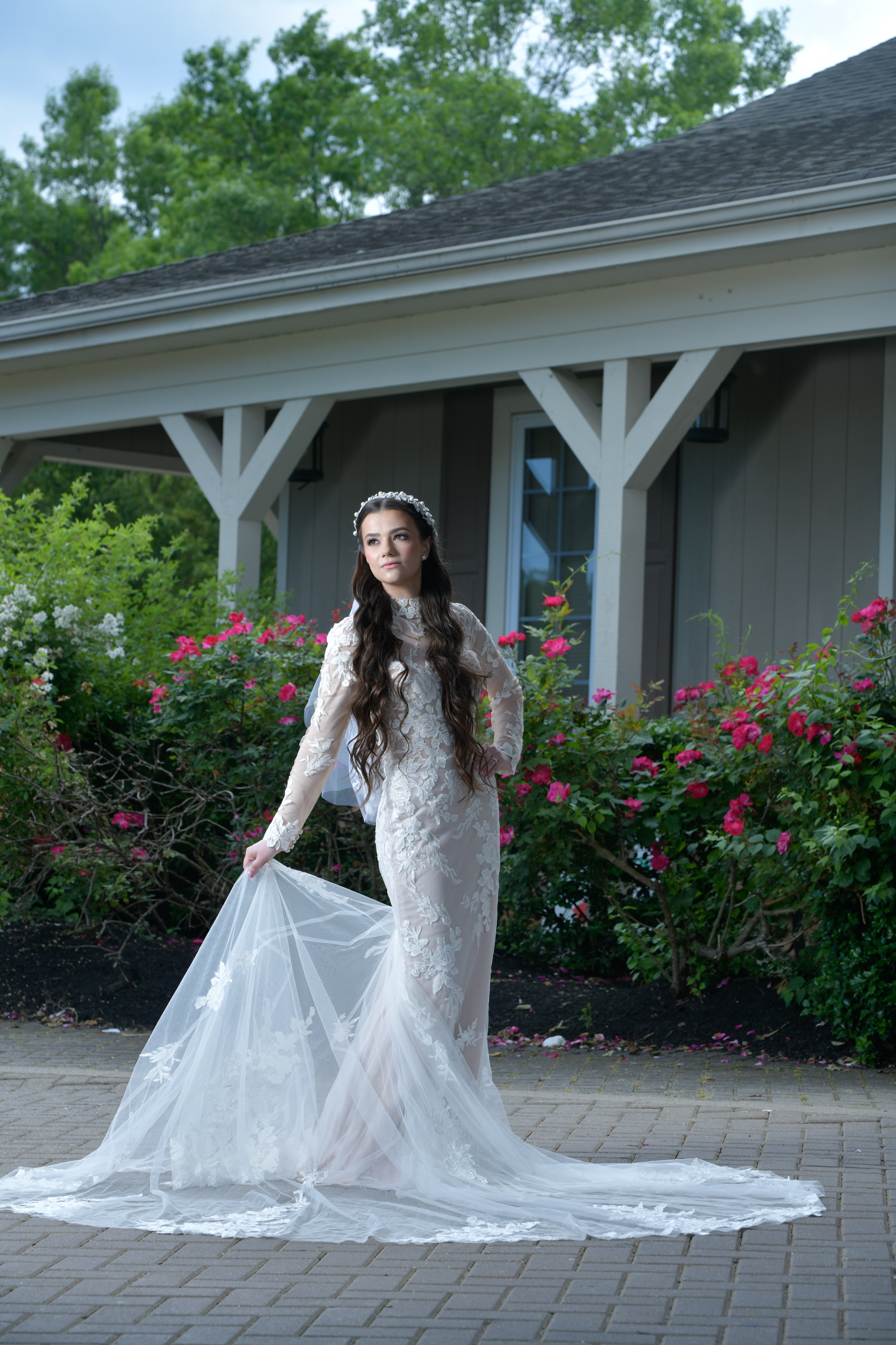 Bride outdoors in lace gown with pink roses