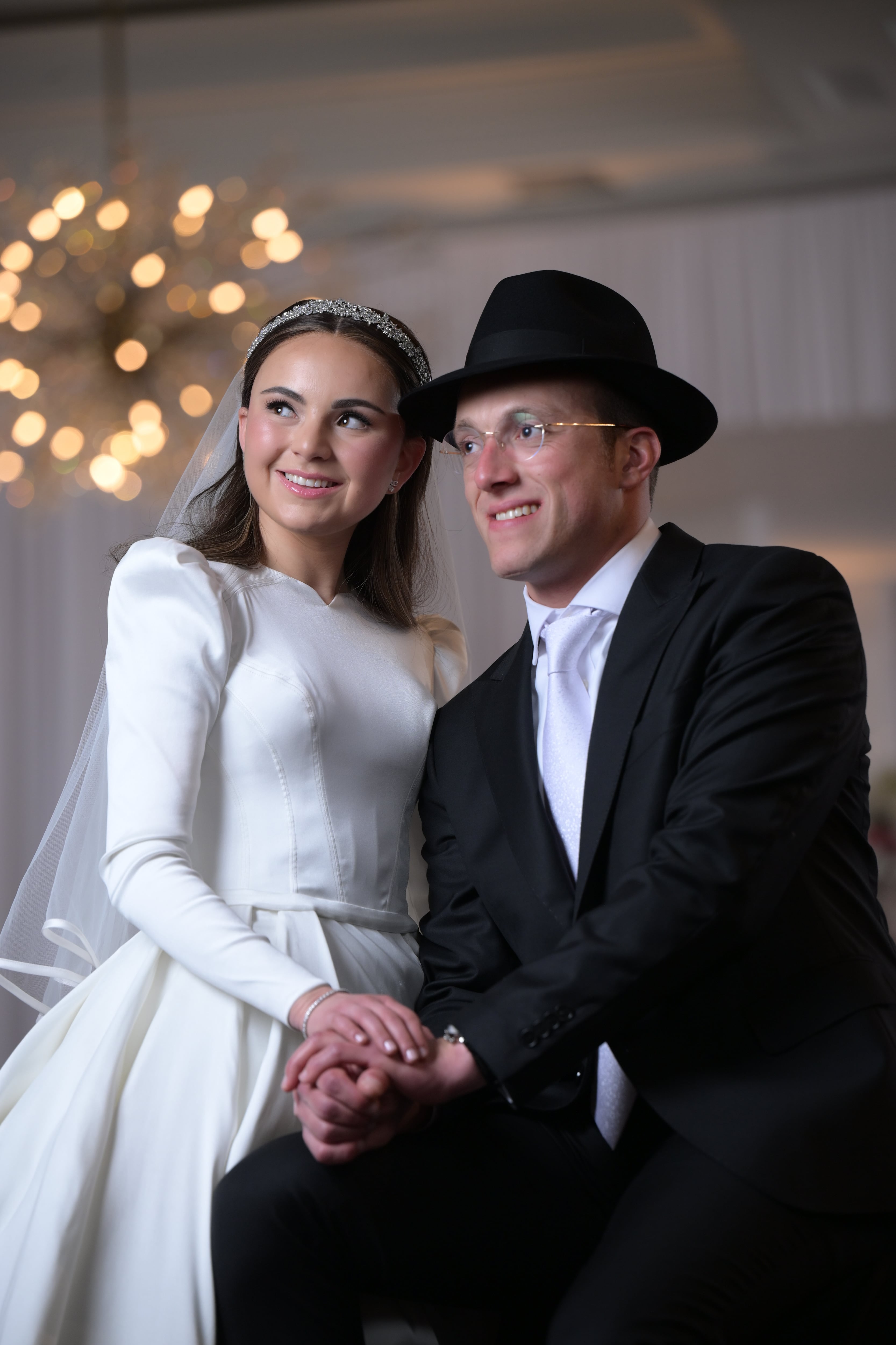 Editorial wedding moment under chandelier