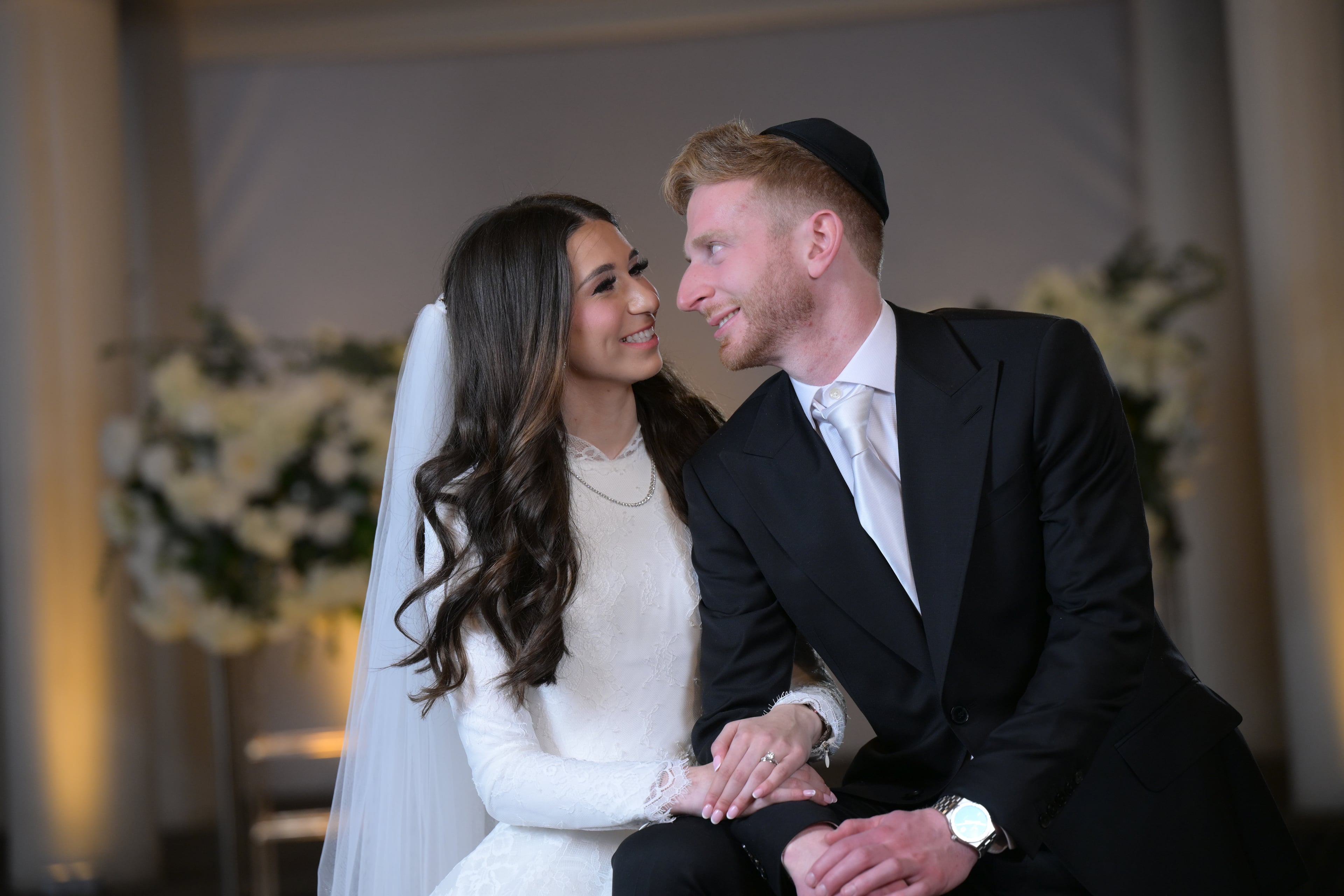 Couple cheek-to-cheek in warm reception lighting